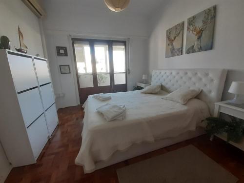 a bedroom with a large white bed and a window at Colombo & Stadium Cozy Flat in Lisbon