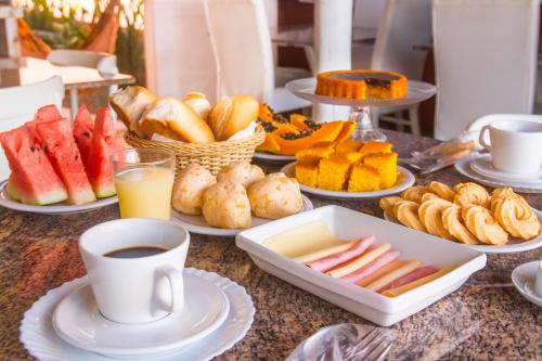 een tafel met borden eten en een kopje koffie bij Pousada Viver a Vida in Arraial d'Ajuda