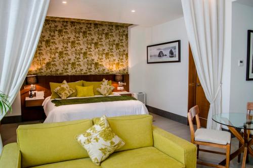 a bedroom with a bed and a couch and a table at Kovay Gardens in Cruz de Huanacaxtle