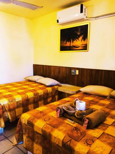a hotel room with two beds and a fan at Hotel Sociedad y Maristas in Tecolutla