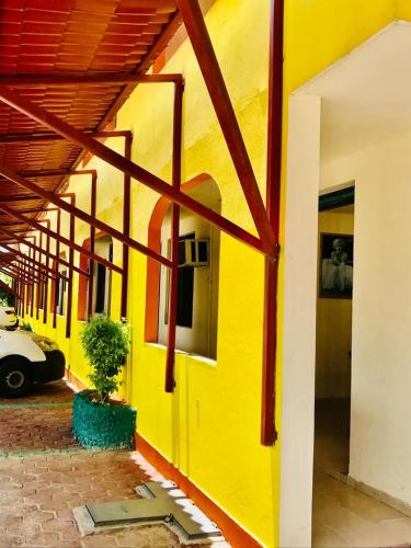 a yellow building with a potted plant next to it at Hotel Sociedad y Maristas in Tecolutla