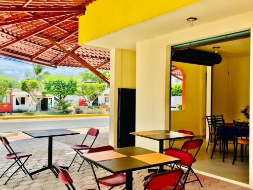 two tables and chairs in a restaurant with a patio at Hotel Sociedad y Maristas in Tecolutla