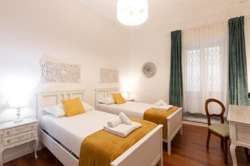 a bedroom with two beds and a desk and a chair at Leonardo Suite Pantheon in Rome