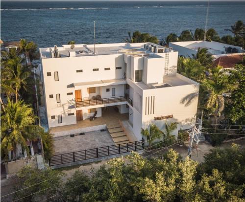 an aerial view of a white house with the ocean at Escalera Al Cielo in Tulum
