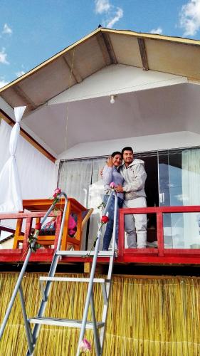 a bride and groom standing on the balcony of a boat at Lake View Lodge in Puno