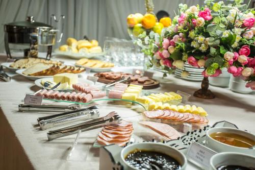 een tafel gevuld met eten, bloemen en desserts bij Dein Haus Pousada in Pomerode