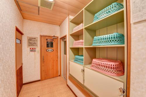 a room with shelves filled with blue and pink dishes at 湯迫温泉旅館 in Ōda