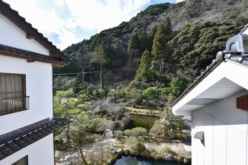 a view of a mountain from between two buildings at 湯迫温泉旅館 in Ōda