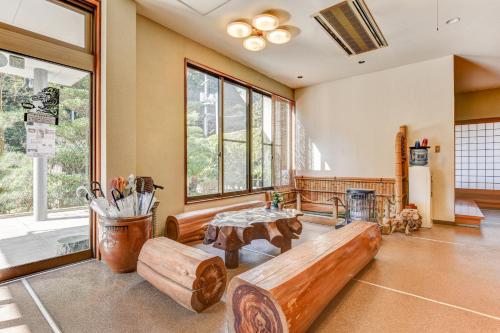 a living room with a bench and a table at 湯迫温泉旅館 in Ōda