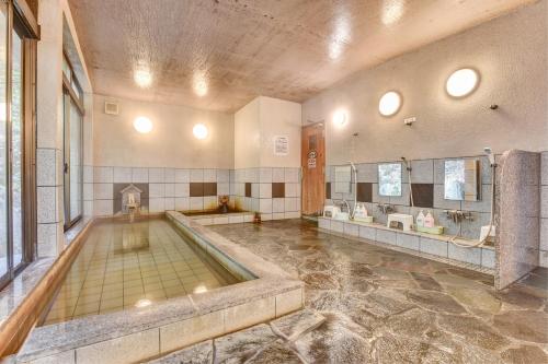 a large bathroom with a swimming pool in the middle at 湯迫温泉旅館 in Ōda