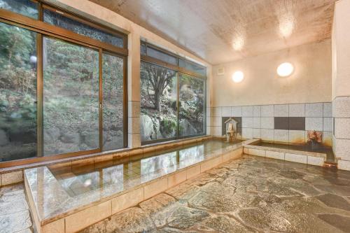 a swimming pool in a room with windows at 湯迫温泉旅館 in Ōda