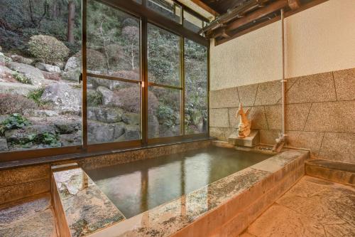 a large pool of water in a room with windows at 湯迫温泉旅館 in Ōda
