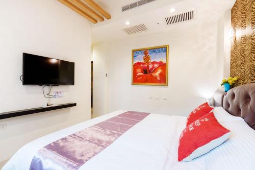 a bedroom with a bed with a flat screen tv at 北歐小宅-市區電梯民宿附停車位 in Hualien City