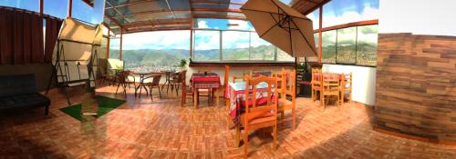 Habitación con mesa, sillas y ventana grande. en Casa Mirador, en Cusco