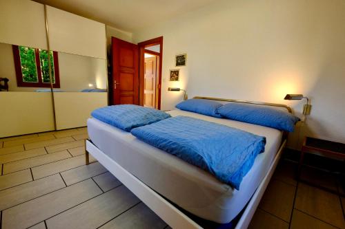 two beds in a room with a bathroom at Chalet Oberhofen am Thunersee in Oberhofen am Thunersee