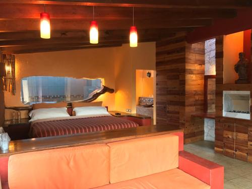 a living room with a couch and a bed at Hotel puesta del sol in Valle de Bravo