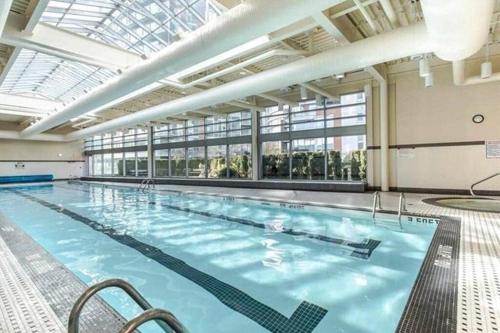 a large indoor swimming pool with a large ceiling at Two Bedroom Apartment with stunning 180 water, mountain and city view Pool Hot Tub and Gym Heart of Downtown Skytrain 3mins walk Right by BC Place Rogers arena in Vancouver
