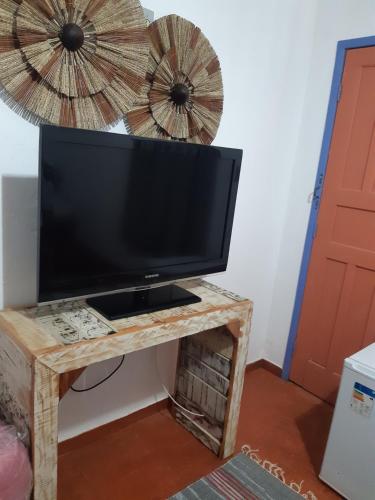 uma televisão numa mesa de madeira num quarto em Pouso da Ermelinda em Tiradentes