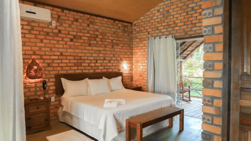 a bedroom with a bed and a brick wall at Rancho das Estrelas in Carolina