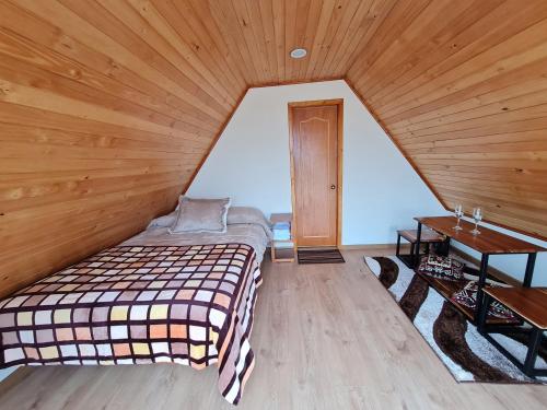 a bed in a room with a wooden ceiling at ReLuna Guatavita Glamping & Suites in Guatavita