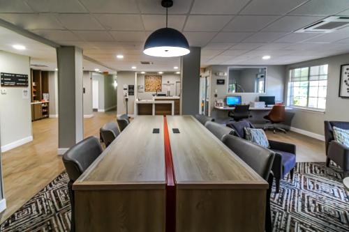 a conference room with a large wooden table and chairs at Candlewood Suites Melbourne/Viera by IHG in Melbourne