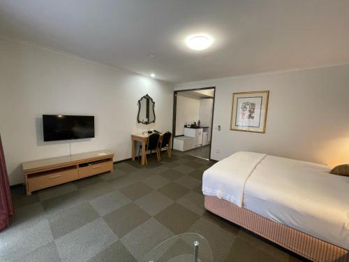 a bedroom with a bed and a desk at Country Plaza Halls Gap in Halls Gap