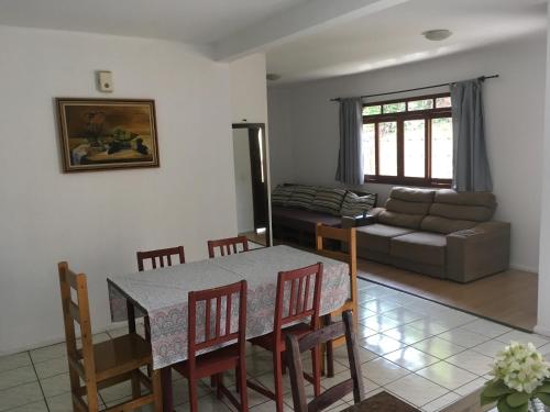 a living room with a table and chairs and a couch at Casa com varanda próximo da Natureza in Foz do Iguaçu