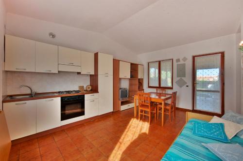 a kitchen with white cabinets and a table and chairs at Villetta Casardi in Monte Nai