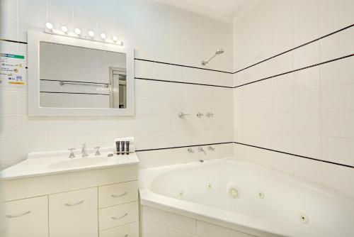 a white bathroom with a tub and a sink at Snow Ski Apartments 34 in Falls Creek