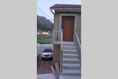a small house with a car parked in front of it at Fogar no mar in O Pindo