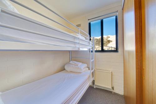 a room with two bunk beds and a window at Snow Ski Apartments 06 in Falls Creek