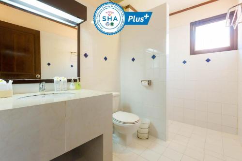 a bathroom with a toilet, sink, and mirror at Sunrise Resort- Koh Phangan - SHA Extra Plus in Haad Rin