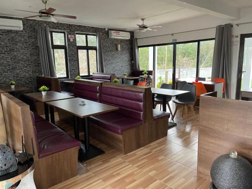 a restaurant with purple chairs and tables and windows at Welcome Inn in Grand Baie