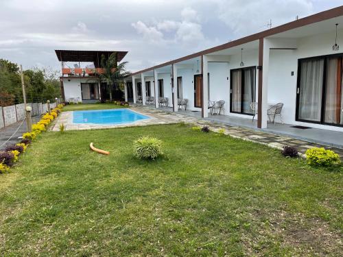 a house with a yard and a swimming pool at Welcome Inn in Grand Baie