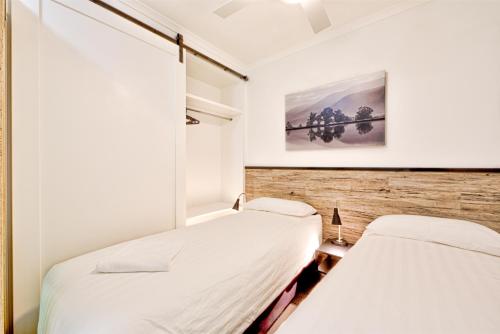 2 letti in una piccola camera con pareti bianche di Snow Ski Apartments 07 a Falls Creek