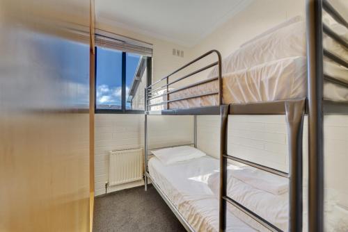 a bedroom with two bunk beds and a window at Snow Ski Apartments 09 in Falls Creek