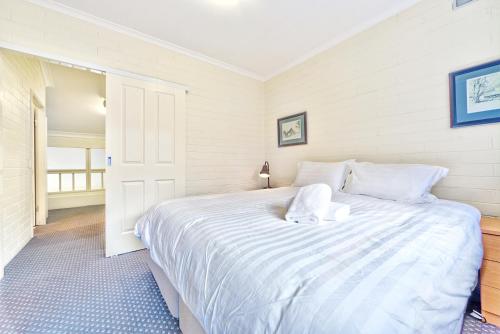 a bedroom with a large white bed in a room at Snow Ski Apartments 31 in Falls Creek