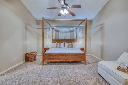 a bedroom with a canopy bed with a ceiling fan at Casa De Arbol in El Paso