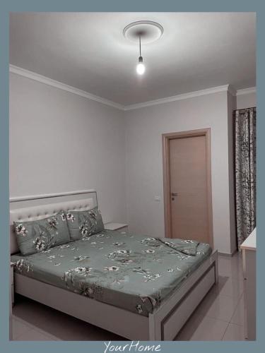 a bedroom with a bed in a white room at YourHome in Tirana