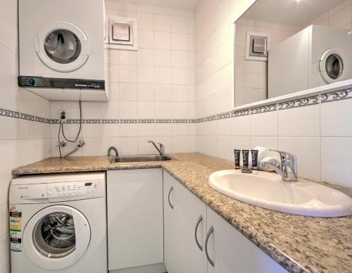 Un baño con lavadora y lavabo. en Snow Ski Apartments 28, en Falls Creek