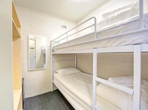 a bedroom with two bunk beds and a mirror at Snow Ski Apartments 27 in Falls Creek