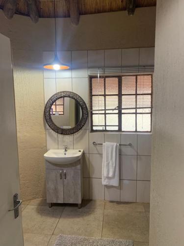 a bathroom with a sink and a mirror at Selati River Ruins in Gravelotte