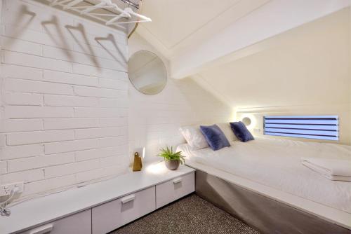 a white bedroom with a bed and a tub at Snow Ski Apartments Penthouse 33 in Falls Creek