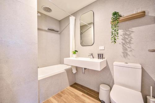 a bathroom with a sink and a toilet and a mirror at Snow Ski Apartments Penthouse 33 in Falls Creek