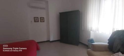 a living room with a red couch and a black door at Mamena in Paestum