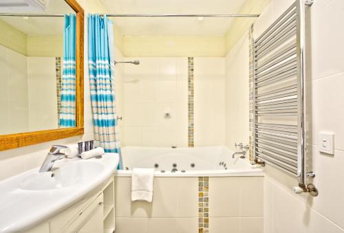 a white bathroom with a tub and a sink at Snow Ski Apartments 26 in Falls Creek
