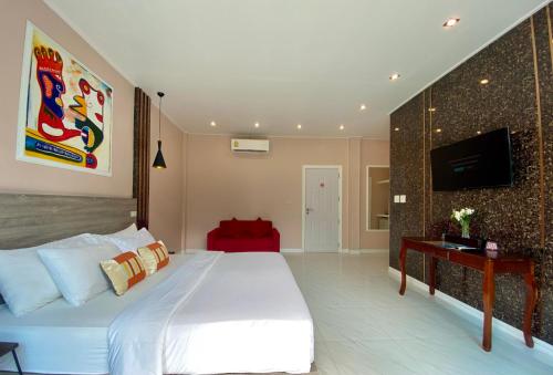 a bedroom with a white bed and a tv on a wall at Koh Kood BED's in Ko Kood
