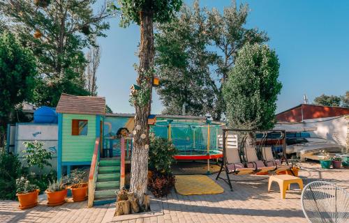 a play area with a house and a tree at Laguna Beach Club Bazaleti Lake in Dushetʼi