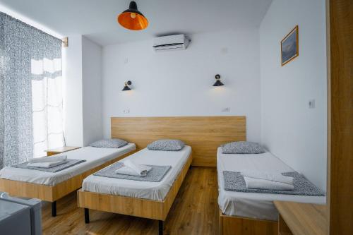 a room with two beds and a window at Laguna Beach Club Bazaleti Lake in Dushetʼi