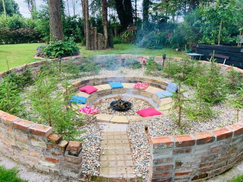 a garden with a fire pit in a brick wall at Fortwilliam Farm T12DNN2 in Cork